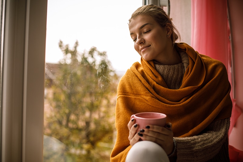 5 Tips to Improve Your Indoor Air Quality This Fall. Woman enjoying perfect indoor air quality.