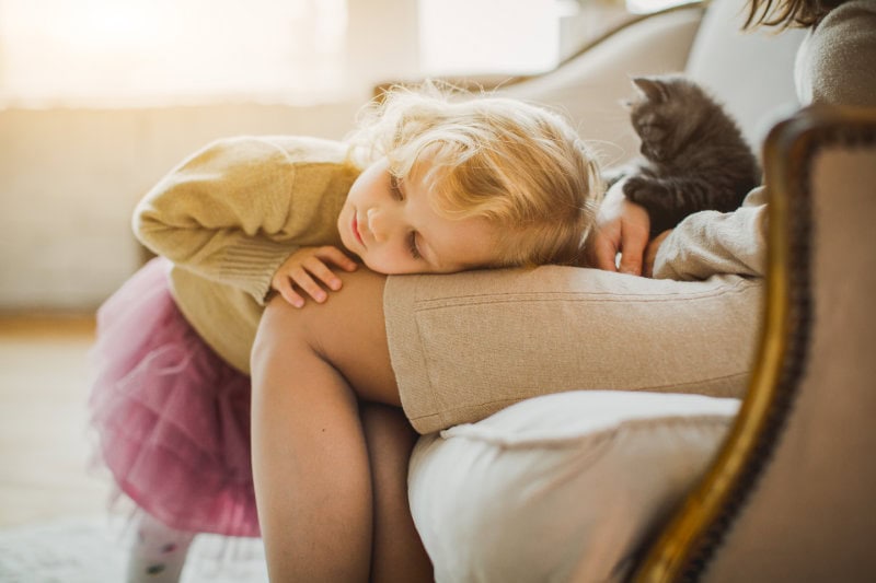 The Basics of Winter Indoor Air Quality. Little girl laying her head on her moms lap.